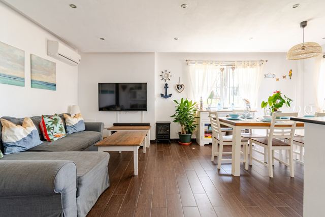 Wohnzimmer mit Ecksofa und 55-Zoll-TV