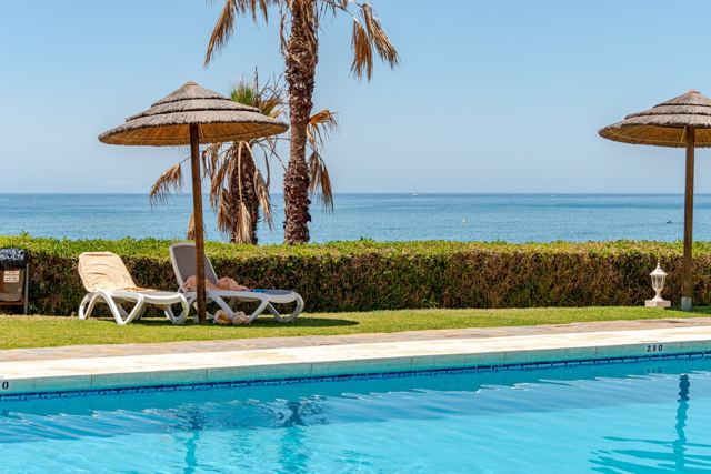 Gemeinschaftspool mit Palmen und Meerblick